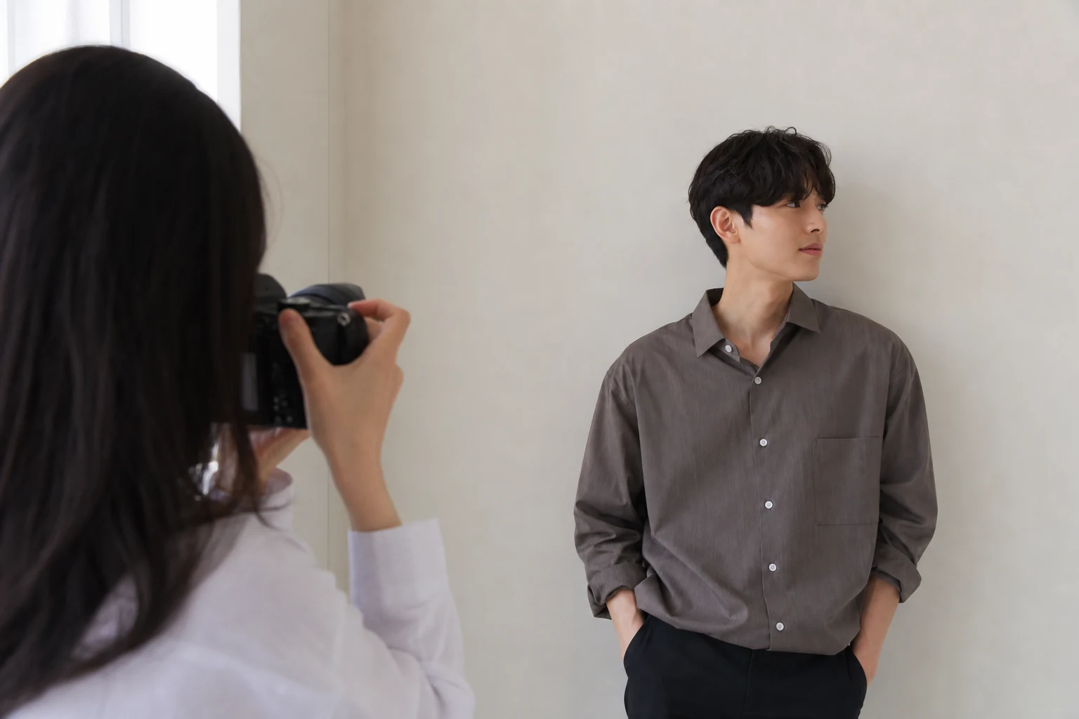 シンプルな背景の前でプロフィール写真を撮る人