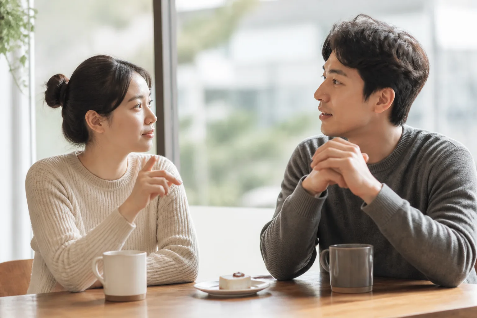 계속 내가 더 내는 것 같을 때 상황에서 집이나 카페에 마주 앉아 표정과 손짓으로 솔직하게 대화하는 한국 성인 두 사람